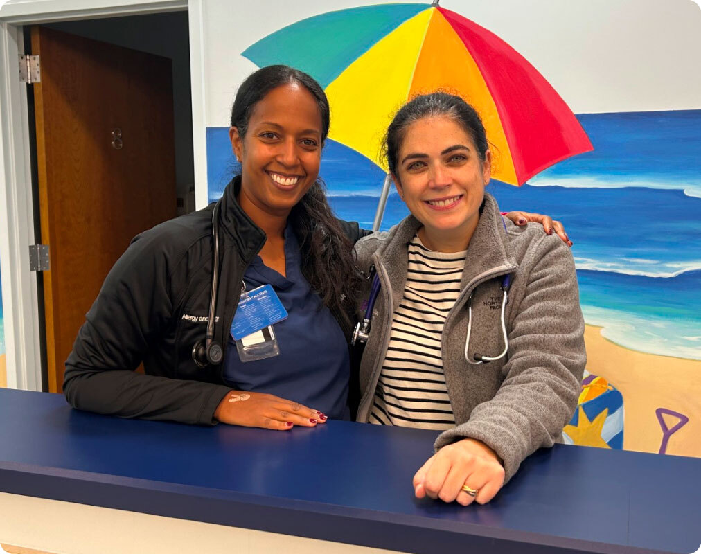 Two nurses posing together in one of Pm Pediatrics Urgent Care offices
